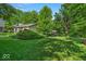 Beautifully landscaped yard with lush green grass and mature trees providing plenty of shade at 2011 Pin Oak Ct, Indianapolis, IN 46260