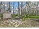 Backyard view featuring a storage shed and mature trees at 2308 Galahad Dr, Indianapolis, IN 46228