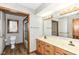 Well-lit bathroom featuring a double sink vanity and patterned wallpaper at 2308 Galahad Dr, Indianapolis, IN 46228