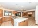 Traditional kitchen with wood cabinets, an island with cooktop, and a pass-through to the living room at 2308 Galahad Dr, Indianapolis, IN 46228