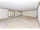 Bright living room with plush carpeting, a decorative chandelier, and multiple windows at 2308 Galahad Dr, Indianapolis, IN 46228