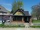 An exterior shot of a cottage-style home with yellow shingles and a picket fence at 3320 E New York St, Indianapolis, IN 46201