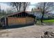 View of garage with missing roofing and boarded-up walls, indicating renovation potential at 3320 E New York St, Indianapolis, IN 46201