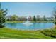 Scenic pond with a fountain, surrounded by lush greenery and neighborhood homes at 358 W Tansey Xing, Westfield, IN 46074