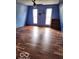 A bedroom with dark wood laminate flooring, light-blue walls and two windows at 38 Homestead Dr, Sheridan, IN 46069