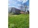 Gambrel roof design of the home showing the lawn, trees and shrubbery at 38 Homestead Dr, Sheridan, IN 46069