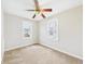 A bright bedroom showcasing two windows, neutral walls, tan carpet, and a ceiling fan at 3826 Delaware St, Anderson, IN 46013
