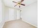 A clean bedroom offers neutral walls, tan carpet, a ceiling fan, and access to closet and hallway at 3826 Delaware St, Anderson, IN 46013
