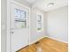 Sunlit entryway with hardwood floors, white door, and large window at 3826 Delaware St, Anderson, IN 46013