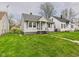 Attractive bungalow with a lush green lawn and sidewalk leading to the front door at 3826 Delaware St, Anderson, IN 46013