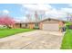 Attractive brick home with an attached two-car garage and well-maintained landscaping enhances its curb appeal at 4013 Colonial Dr, Anderson, IN 46012