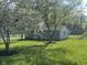 View of backyard featuring a shed, green lawn, and mature trees at 410 S 25Th Ave, Beech Grove, IN 46107
