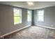 Neutral bedroom with gray walls, plush carpeting, and three bright windows offering natural light at 410 S 25Th Ave, Beech Grove, IN 46107