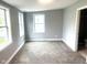 Spacious bedroom featuring neutral gray walls, carpet flooring, and windows providing natural light at 410 S 25Th Ave, Beech Grove, IN 46107