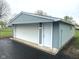 Detached garage with a new door, blue siding, and a new paved driveway at 410 S 25Th Ave, Beech Grove, IN 46107