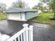 Detached garage with a new door, blue siding, and a new paved driveway at 410 S 25Th Ave, Beech Grove, IN 46107