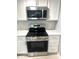 Contemporary kitchen featuring a stainless steel oven and microwave with white cabinets, set against a marble backsplash at 410 S 25Th Ave, Beech Grove, IN 46107