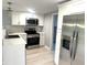 Modern kitchen featuring stainless steel appliances, white cabinets, and elegant countertops with a stylish backsplash at 410 S 25Th Ave, Beech Grove, IN 46107