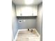 Clean laundry room with gray walls, white cabinets, and laminate flooring, ready for appliances at 410 S 25Th Ave, Beech Grove, IN 46107