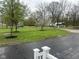 Large front yard with mature trees and fresh asphalt at 410 S 25Th Ave, Beech Grove, IN 46107