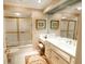 Bright bathroom features a vanity with double sinks, framed mirrors, and a glass-enclosed shower at 411 Sugar Tree Ln, Indianapolis, IN 46260