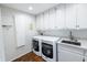 Functional laundry room with modern appliances, ample cabinet space, and a convenient utility sink at 411 Sugar Tree Ln, Indianapolis, IN 46260