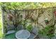 Cozy patio area with lattice fence, climbing vines, potted plants and outdoor furniture for relaxing in the garden at 411 Sugar Tree Ln, Indianapolis, IN 46260