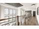 Bright hallway with modern railing, transom windows, and hardwood floors at 4292 Alderborough Way, Zionsville, IN 46077