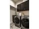 Laundry room with front load washer and dryer, dark cabinets, and granite countertop sink at 4292 Alderborough Way, Zionsville, IN 46077