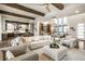 Open-concept living area featuring modern furniture, wood floors, and an open layout to the kitchen area at 4292 Alderborough Way, Zionsville, IN 46077