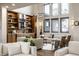 Bright living room with floor-to-ceiling windows, built-in cabinets and seating area with hardwood floors at 4292 Alderborough Way, Zionsville, IN 46077