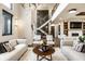 Open-concept living room with white couches, fireplace, and a staircase to the upper level at 4292 Alderborough Way, Zionsville, IN 46077