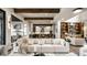 Inviting living room showcasing a modern design with wood beam accents and open flow to the kitchen at 4292 Alderborough Way, Zionsville, IN 46077