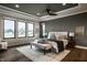 Serene main bedroom with tray ceiling, large windows, stylish furnishings, hardwood floors, and neutral decor at 4292 Alderborough Way, Zionsville, IN 46077