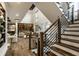 Elegant staircase with modern railings, leading to the upper level, and a view of the open living area at 4292 Alderborough Way, Zionsville, IN 46077