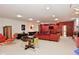 Finished basement features a pool table, ping pong table, and entertainment area with comfortable seating and bright red accent wall at 5528 State Road 144, Greenwood, IN 46143