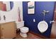 Unique bathroom features a toilet, urinal, and a stylish vanity, with striking blue walls and a modern design at 5528 State Road 144, Greenwood, IN 46143