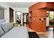Spacious bedroom with a large platform bed, wood paneled walls, and access to an outside courtyard at 5528 State Road 144, Greenwood, IN 46143