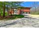 Exterior shot of the property with a three-car garage, complemented by lush greenery and trees at 5528 State Road 144, Greenwood, IN 46143