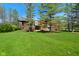 Stunning front exterior featuring a modern design and lush green lawn in a wooded area at 5528 State Road 144, Greenwood, IN 46143