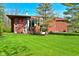 Striking front of home with a modern architectural design and well-manicured lawn in a wooded area at 5528 State Road 144, Greenwood, IN 46143