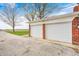 Two-car garage with white doors and brick facade, offering ample parking and storage space at 5541 S County Road 150 E, Clayton, IN 46118