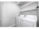 Bright laundry room featuring a white washer and dryer with overhead shelving at 5541 S County Road 150 E, Clayton, IN 46118