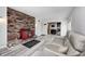 Cozy living room featuring a decorative brick accent wall, fireplace, and comfortable couch at 5541 S County Road 150 E, Clayton, IN 46118