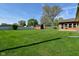 Beautiful backyard featuring a lush green lawn, a fire pit, and a shed at 5693 W Walnut St, Greenwood, IN 46142