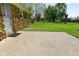 Backyard view showcasing a concrete patio, lush lawn, and the exterior stone detail of the home at 5693 W Walnut St, Greenwood, IN 46142