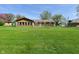 Wide backyard shot revealing the home's rear facade, a fire pit, and lush green grass at 5693 W Walnut St, Greenwood, IN 46142