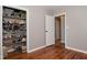 Bedroom featuring hardwood floors, gray walls, closet with storage, and doorways to other rooms at 5693 W Walnut St, Greenwood, IN 46142