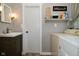 Functional laundry room featuring a sink with cabinet, laundry machine, and useful shelving at 5693 W Walnut St, Greenwood, IN 46142