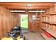 Organized shed interior featuring a riding lawn mower, shelves, and an open door view at 5693 W Walnut St, Greenwood, IN 46142